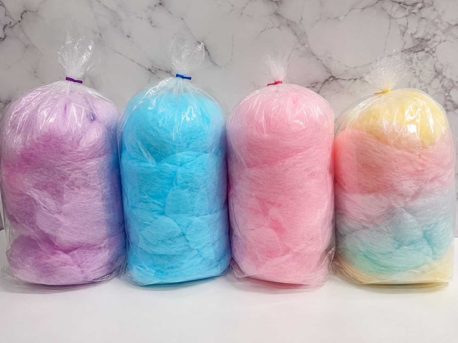 Pink, blue, yellow, and rainbow cotton candy packaged for an event