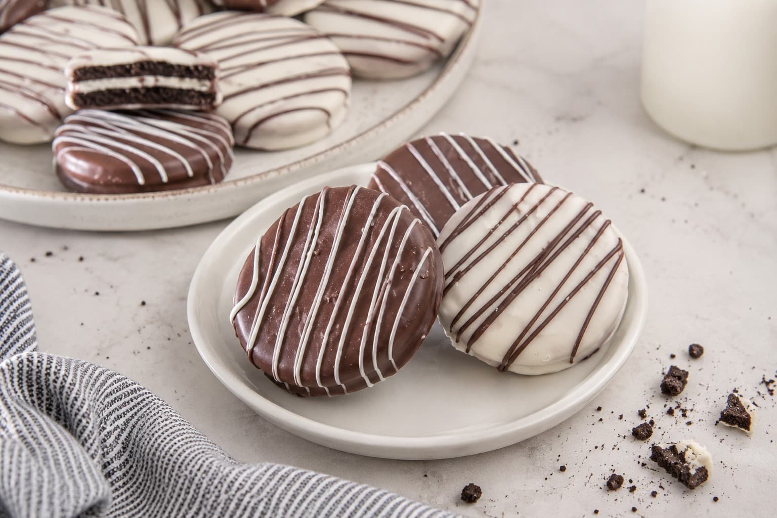Chocolate-dipped Oreos decorated with white and chocolate drizzle